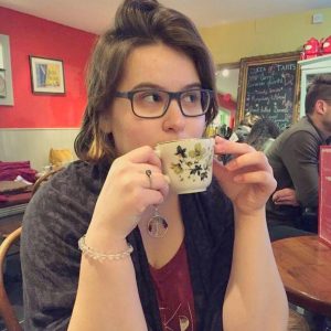 a young woman holds a tea cup up to her face